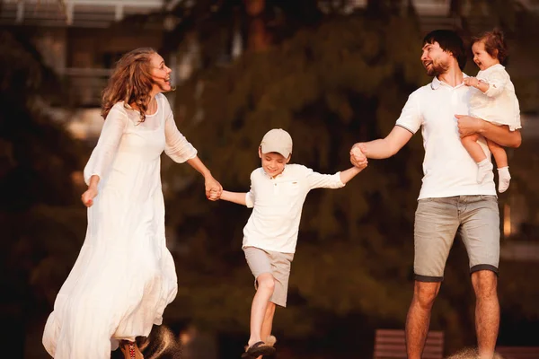 Gelukkig Gezin Witte Kleren Hand Hand Vooruit Rennen Lachen — Stockfoto