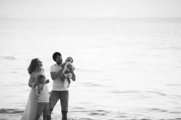 Young Happy Family White Clothes Stands Beach Sunset — Stock Photo, Image