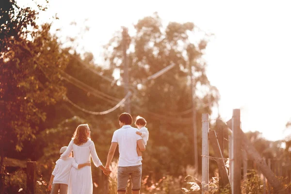 Família Feliz Roupas Brancas Andando Juntas Estrada Pôr Sol — Fotografia de Stock