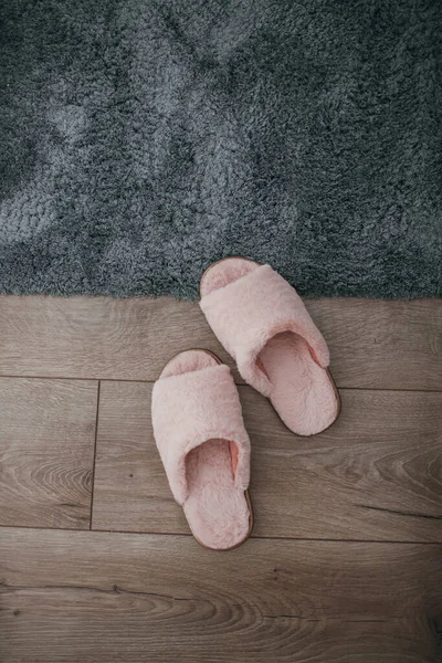  ... mavi halı ve gri yatağın yanındaki parke zeminde pembe kürk terlik vardı.