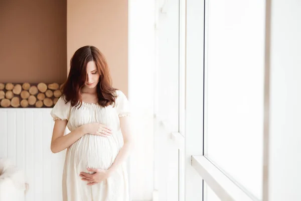 Vacker Gravid Kvinna Vit Klänning Står Nära Fönstret — Stockfoto