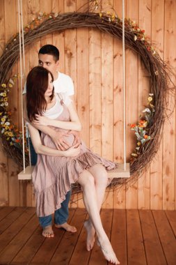 Mutlu anne babalar ahşap arka planda salıncakla