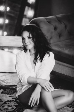 Stüdyoda siyah beyaz poz veren seksi ve çekici genç bir kadın.