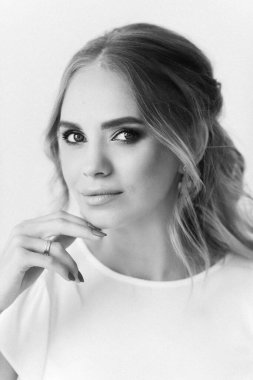 Şık etekli ve bluzlu güzel sarışın manken ahşap salıncakta oturuyor.