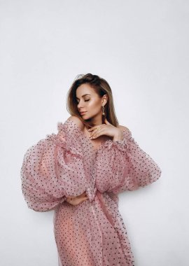 Beyaz arka planda pembe elbiseli güzel sarışın manken.