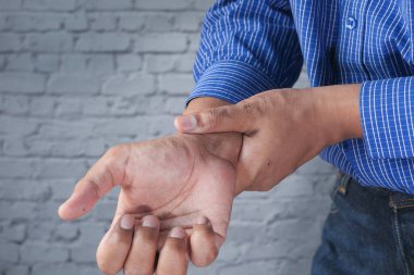 Masada uyurken bilek ağrısı çeken genç bir adam. 