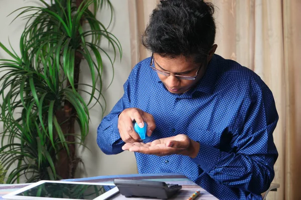 Forretningsmann som bruker hånddesinfeksjonsmiddel for å forebygge virus – stockfoto