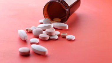 Turuncu arka plana dökülen beyaz hapları kapat 