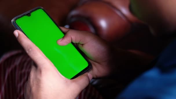 Nahaufnahme eines Mannes, der ein Handy mit grünem Bildschirm benutzt — Stockvideo
