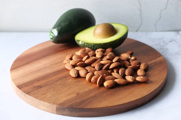 Ovanifrån av mandel och avokado på hackbrädan. — Stockfoto