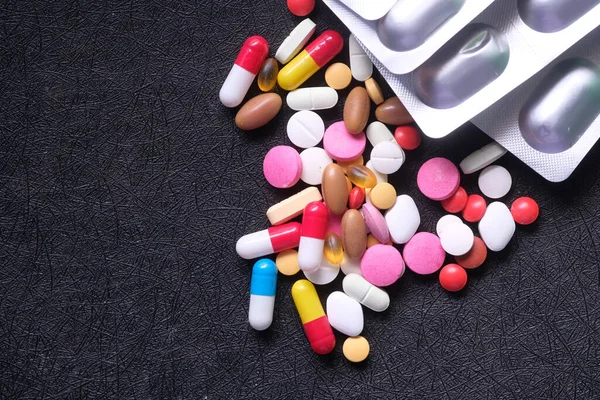 Ovanifrån av färgglada piller och blisterförpackning på mörk bakgrund — Stockfoto