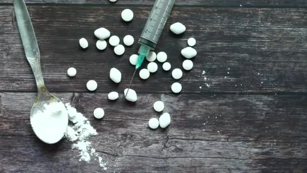 Heroin, fecskendő és tabletták fából készült háttérrel. — Stock videók