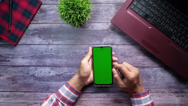 Vista de ángulo alto del hombre utilizando el teléfono inteligente móvil con pantalla verde — Vídeo de stock