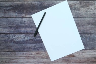Ahşap zemin üzerinde kalem olan boş kağıt 
