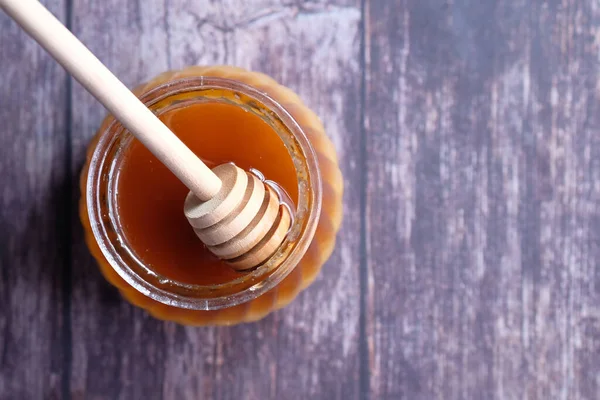 Vista dall'alto di miele fresco in un barattolo sul tavolo di legno . — Foto Stock