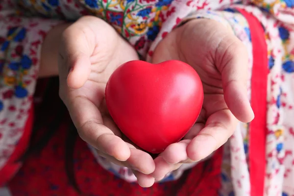 Red heart in hands, donate or charity concept