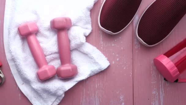 Vista superior do haltere, sapato e garrafa de água no fundo rosa — Vídeo de Stock