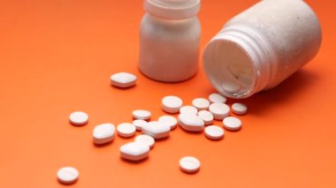 Konteynırdan dökülen beyaz hapların üst görünümü 