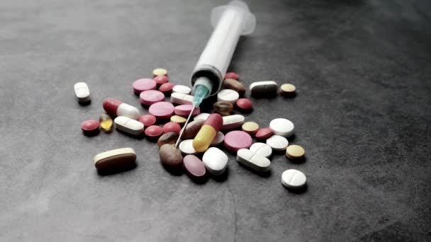 Шприц и таблетки на сером фоне, вид сверху — стоковое видео
