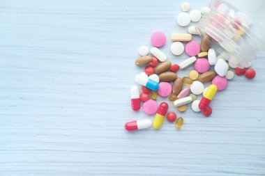 Konteynırdan dökülen beyaz hapların üst görünümü 