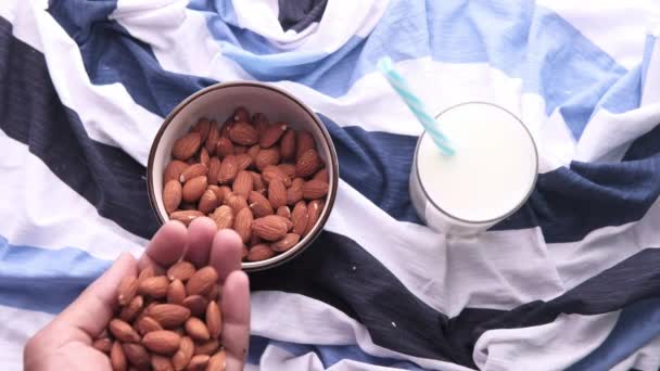 Primer plano de nueces de almendras y leche sobre manteles — Vídeo de stock