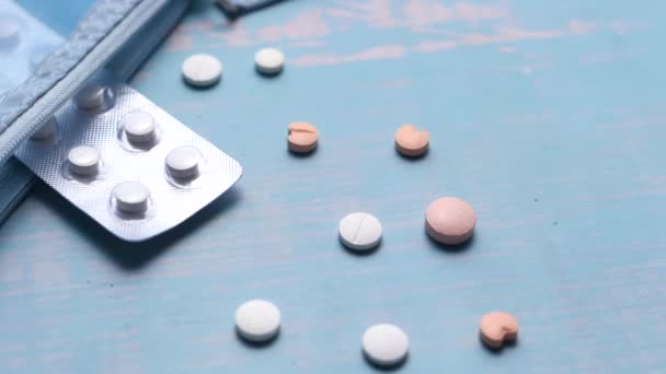 Vista dall'alto di pillole bianche che si rovesciano sul tavolo di legno — Video Stock