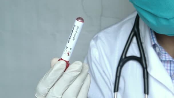 Laboratóriumi technikus kézben tartja a vérvizsgálati csövet — Stock videók