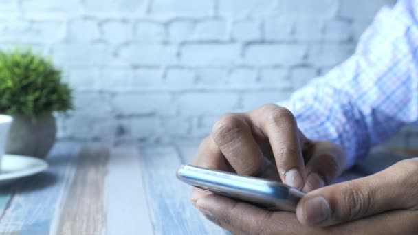 Joven con camisa amarilla usando teléfono inteligente — Vídeos de Stock