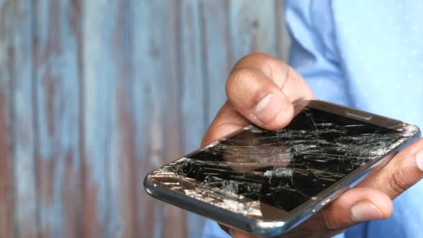 Fechar o homem mão segurando quebrado telefone inteligente — Vídeo de Stock