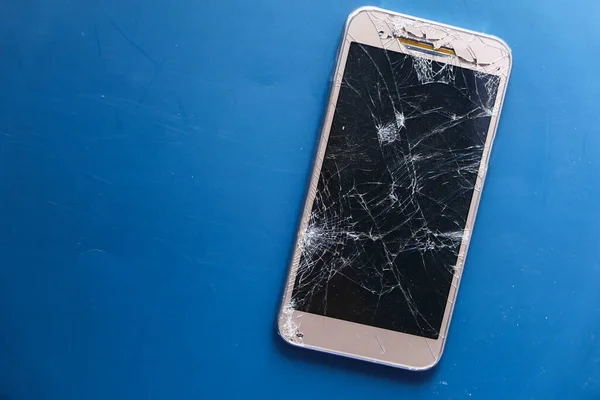 Top view of broken smart phone on color background