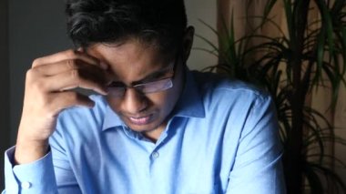 Genç adam hayal kırıklığına uğramış ve baş ağrısı çekiyor..