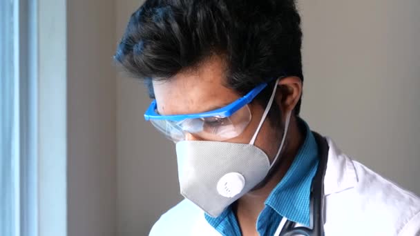 Sad doctor in face mask looking down — Stockvideo