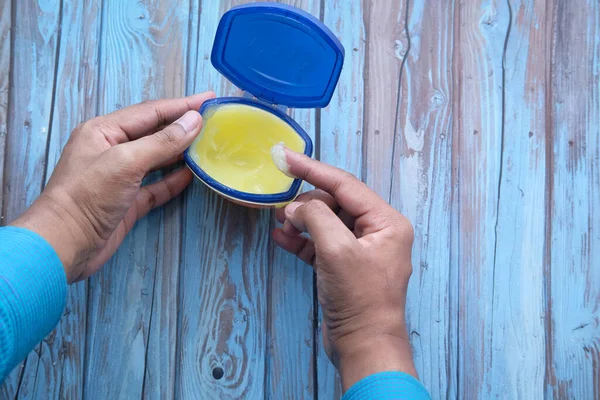 Mans hand using petroleum jelly top down — Stockfoto