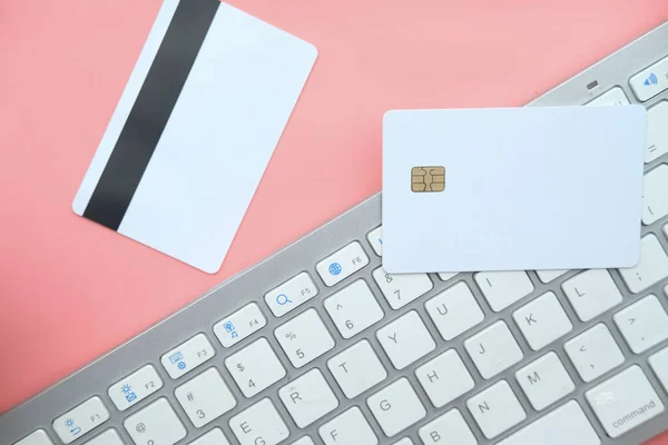 shopping online payment. Card on keyboard on pink desk