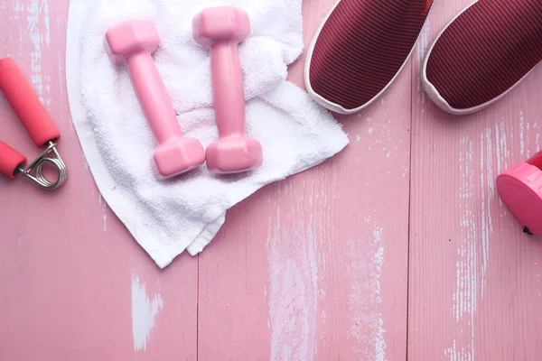 Vista superior de la mancuerna, zapato y botella de agua sobre fondo rosa — Foto de Stock