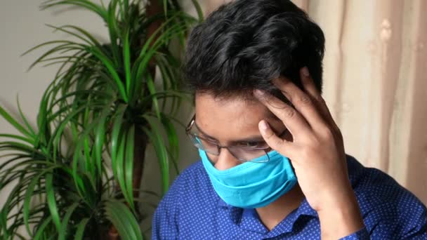 Молодий азіатський чоловік маска на обличчі страждає головним болем — стокове відео