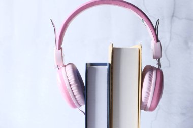 Ses kitabı konsepti. Kulaklıklar ve kitap ahşap masanın üzerinde..