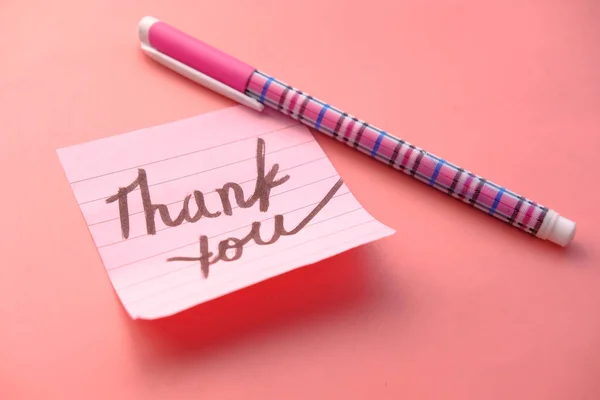 Розовая стильная записка с благодарностью на розовом столе — стоковое фото