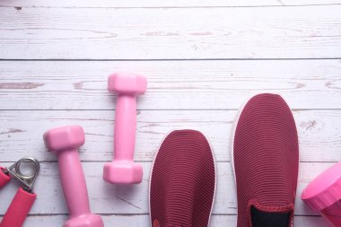 Pembe arka planda dambıl, ayakkabı ve su şişesinin üst görüntüsü 