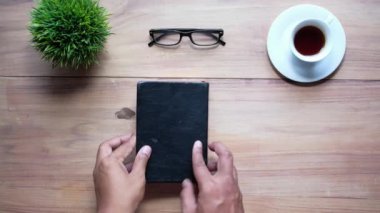 Yüksek açılı adam eli bir kitap sayfasını çeviriyor 