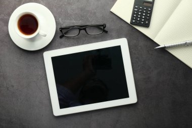 Boş ekranlı dijital tablet ve ofis masasında not defteri 