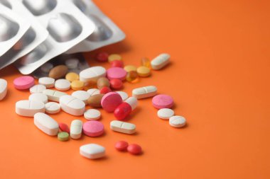 Renkli haplar fotokopi alanı ile turuncu arkaplan üzerine dökülüyor 