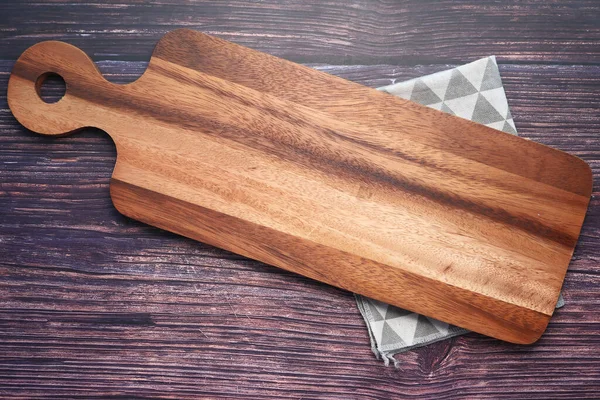 Вид сверху на деревянную разделочную доску и кухонный инструмент на деревянном фоне  . — стоковое фото
