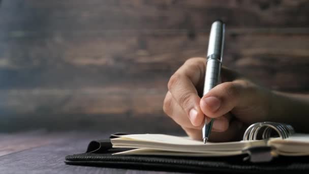 Escritura a mano de las mujeres con la pluma en el bloc de notas — Vídeo de stock