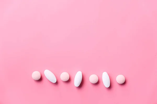 Λευκά χάπια χυθεί σε ροζ φόντο με αντίγραφο χώρο — Φωτογραφία Αρχείου