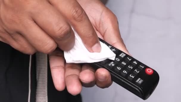 Hombre mano limpieza TV mando a distancia con desinfectante húmedo toallita — Vídeo de stock