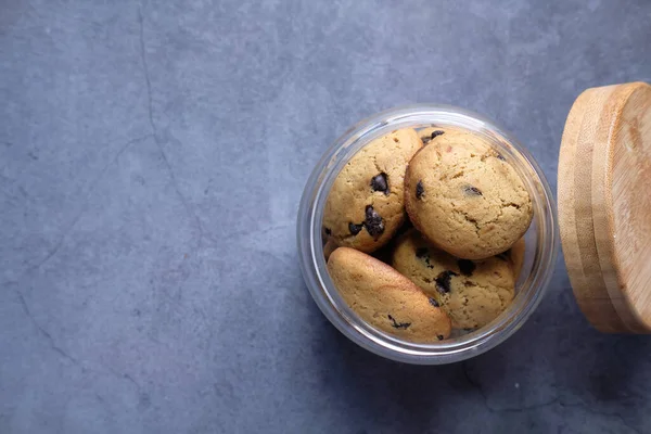 Tarro lleno de galletas de chispas de chocolate sobre fondo negro —  Fotos de Stock