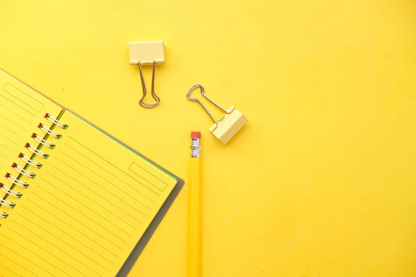 Άποψη υψηλής γωνίας του κίτρινου χρώματος σημειωματάριο με μολύβι στο κίτρινο γραφείο — Φωτογραφία Αρχείου