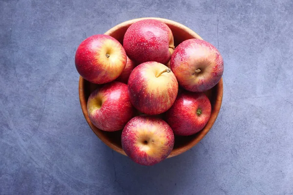 Närbild av färskt äpple i en skål på träbord — Stockfoto