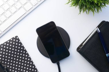 Kablosuz şarj pedi kullanarak akıllı telefon şarj ediliyor, üst görünüm 
